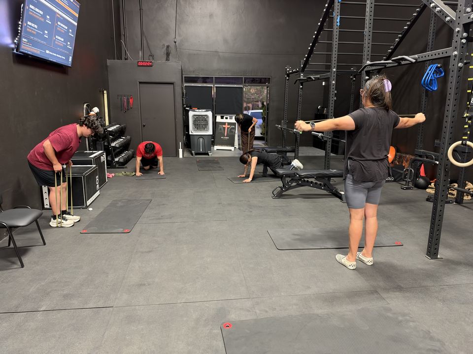 A Strength & Conditioning group class warming up with bands on the ATG Fitness floor in Hesperia